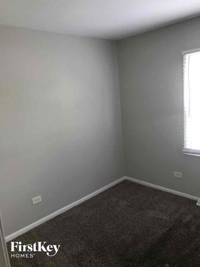 an empty room with a carpet and a window