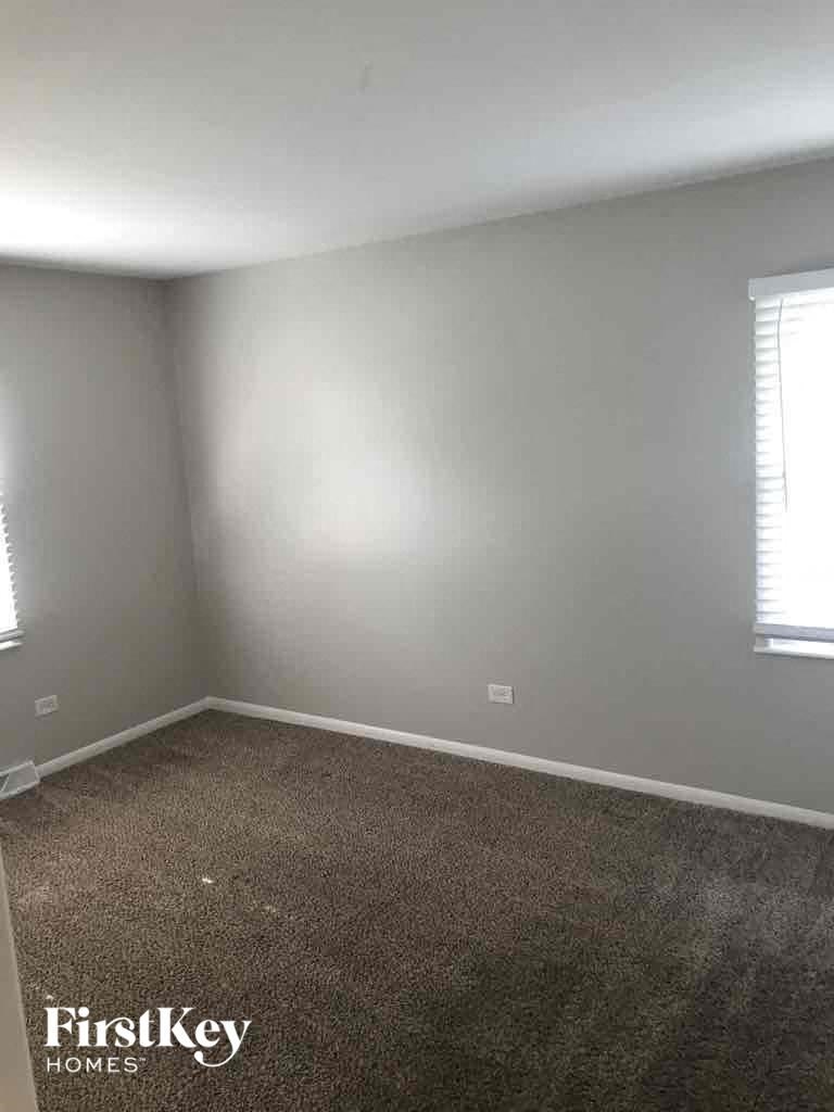 an empty room with gray walls and a brown carpet