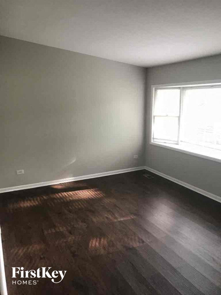 an empty room with wooden floors and a window