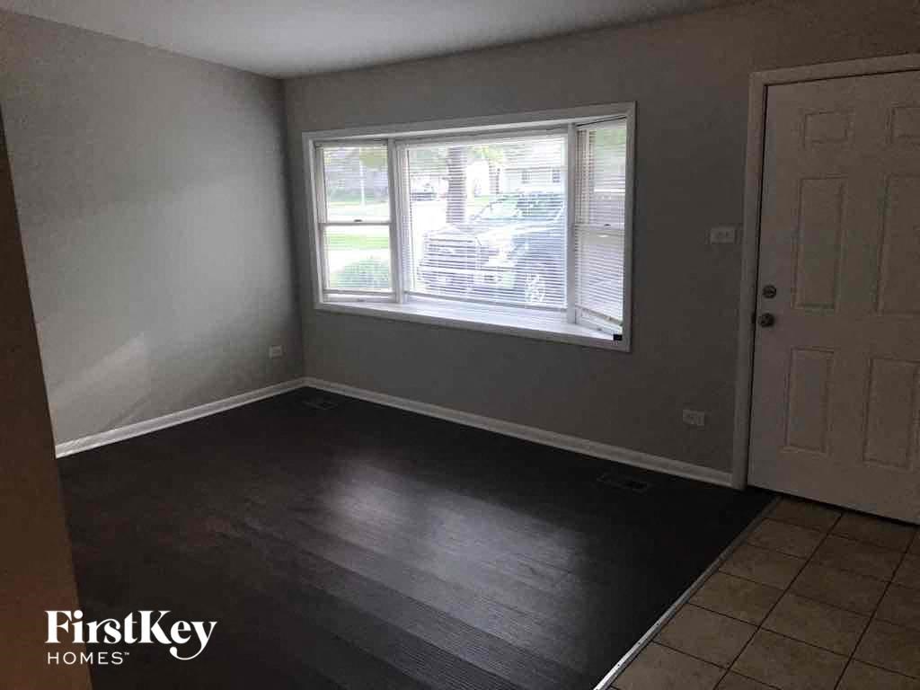 an empty room with wooden floors and a window