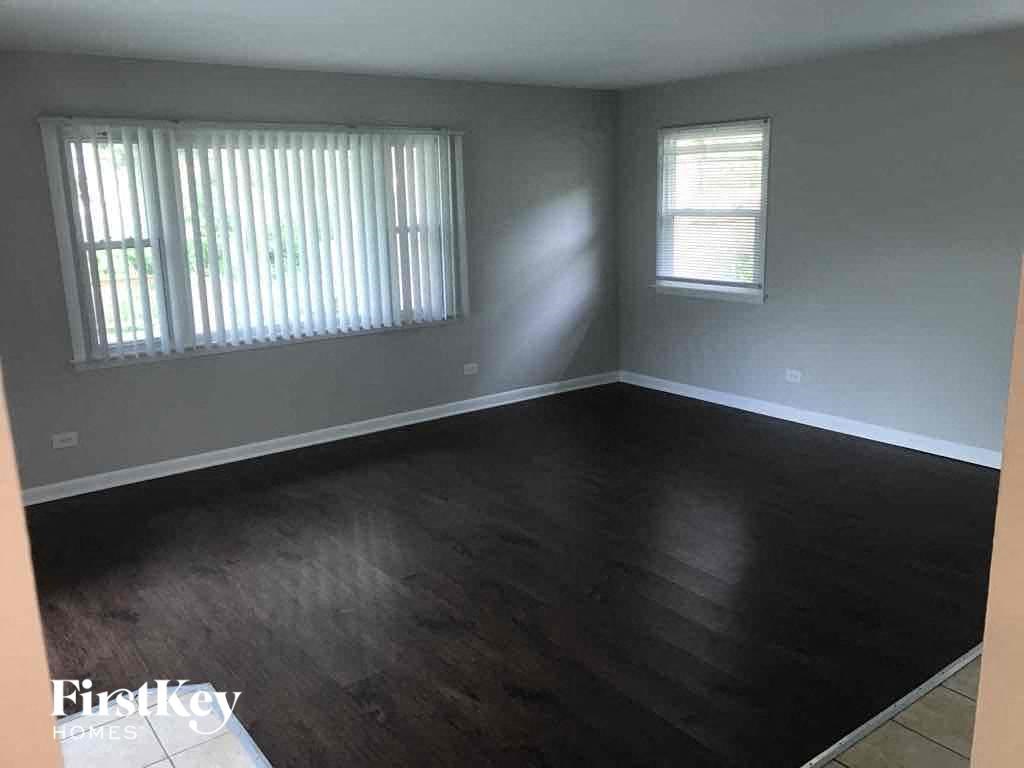 an empty living room with wood floors and a window