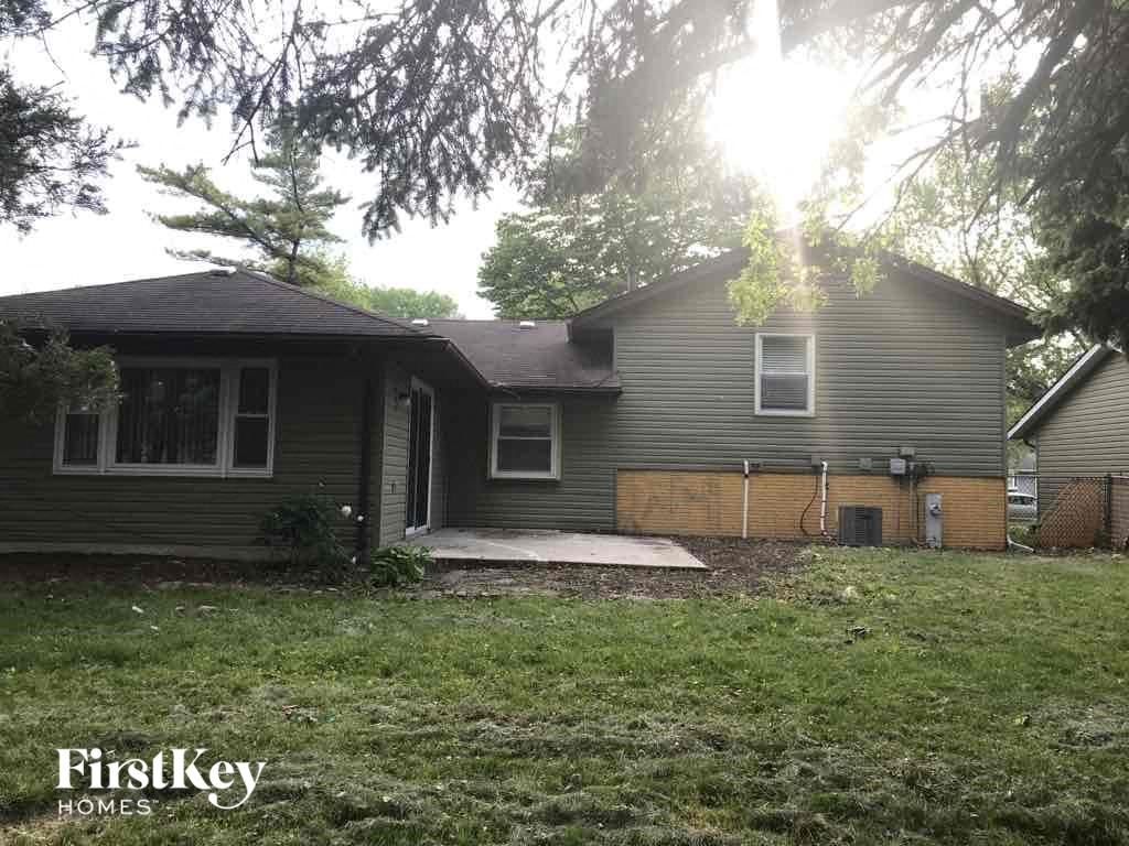 a house with a yard and a fence in front of it