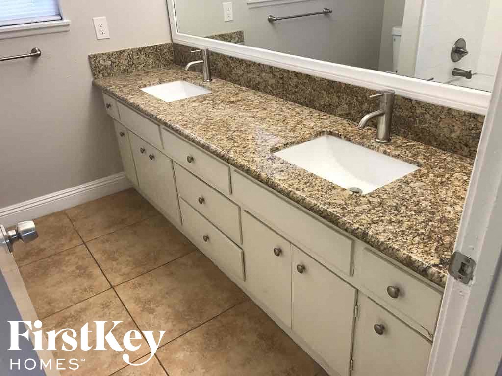 a bathroom with two sinks and a granite counter top