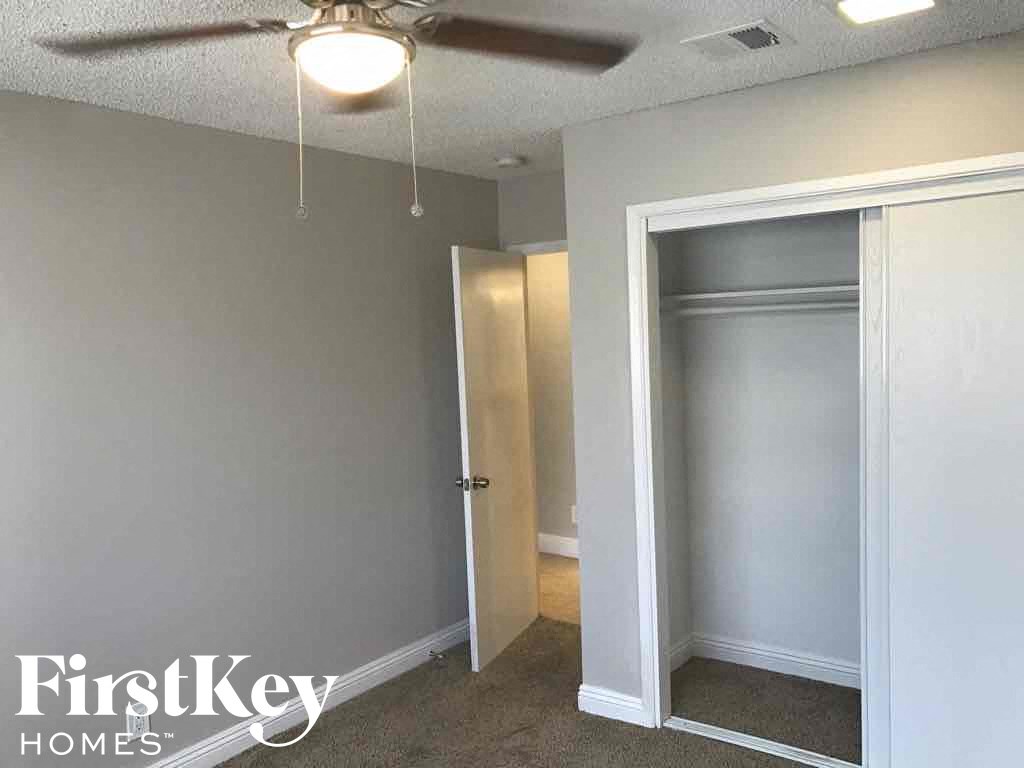 an empty bedroom with a closet and a ceiling fan