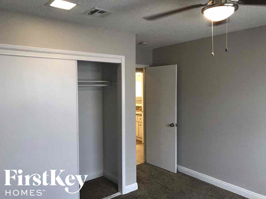 an empty room with a closet and a door to a hallway