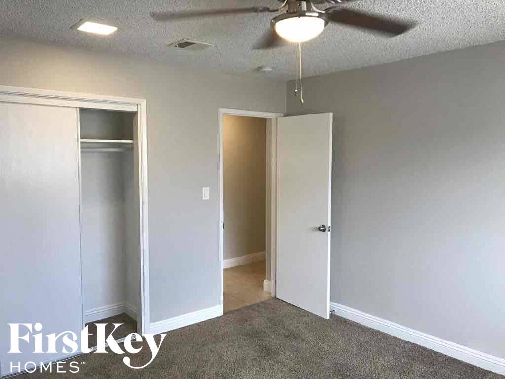 an empty bedroom with a ceiling fan and a closet