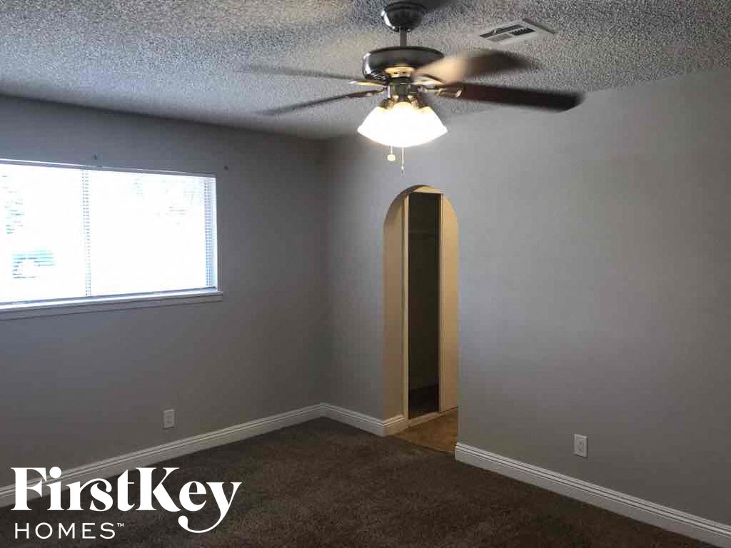 an empty room with a ceiling fan and a door to a closet