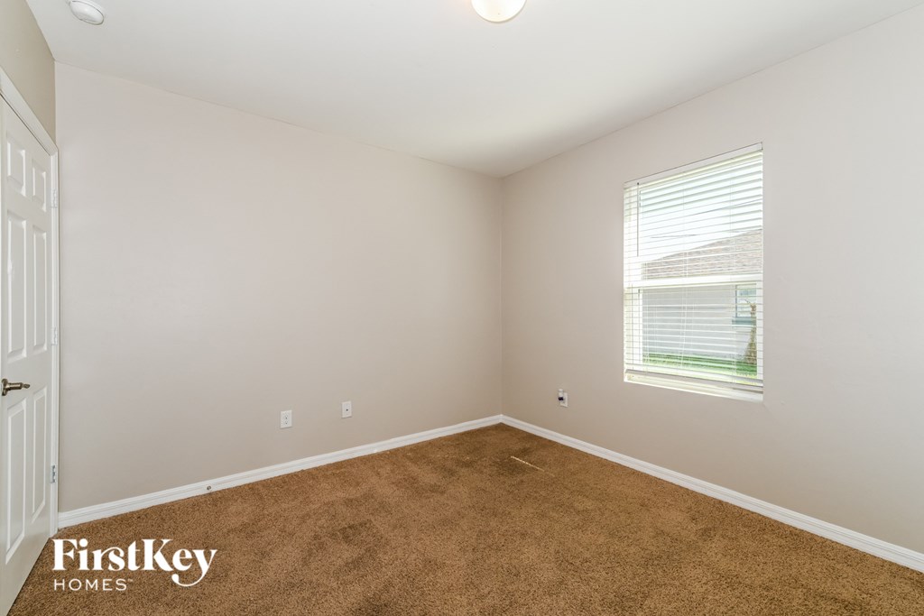 a bedroom with a carpeted floor and a window