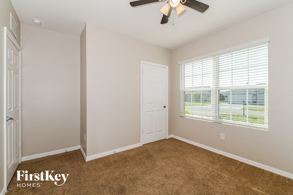 a bedroom with a ceiling fan and a window