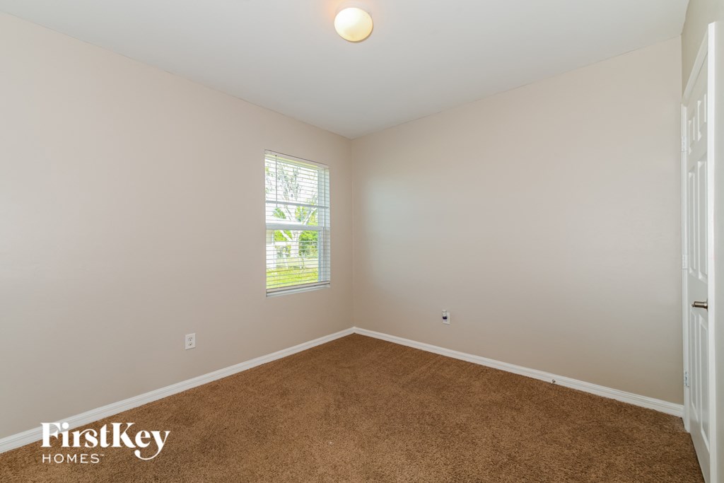 a bedroom with a carpeted floor and a window