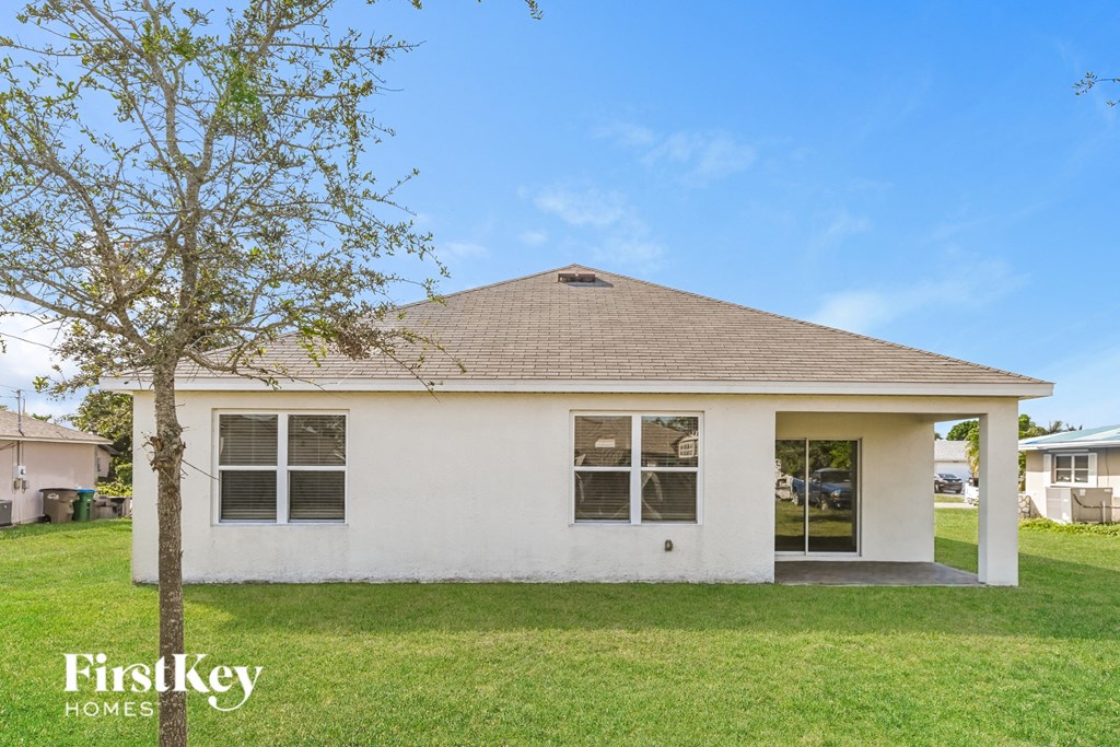 a small white house with a tree in front of it