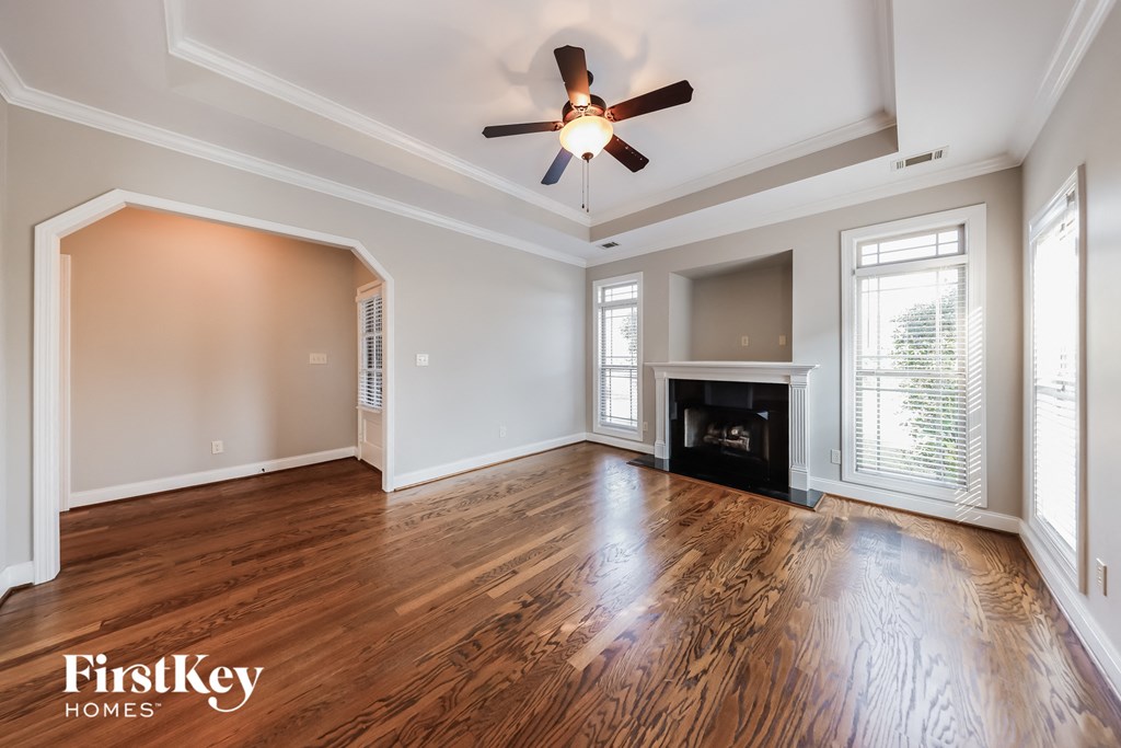 A spacious room with wood flooring and a fireplace.