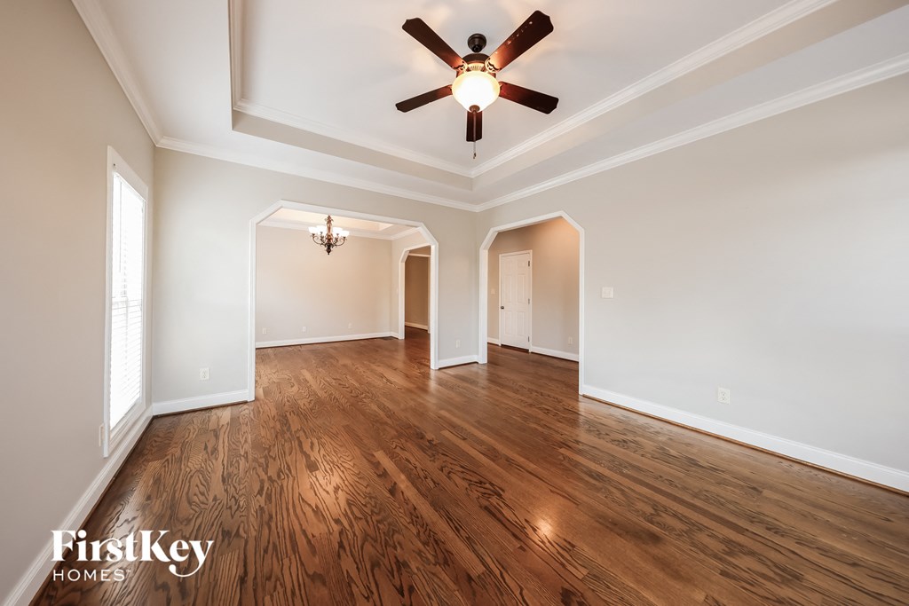A room with wooden floors and a ceiling fan.