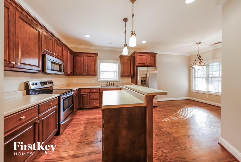A kitchen with wooden cabinets and a brown island.