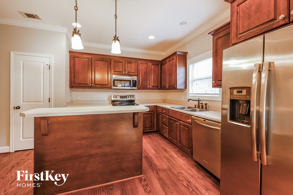 A kitchen with wooden cabinets and a stainless steel refrigerator.