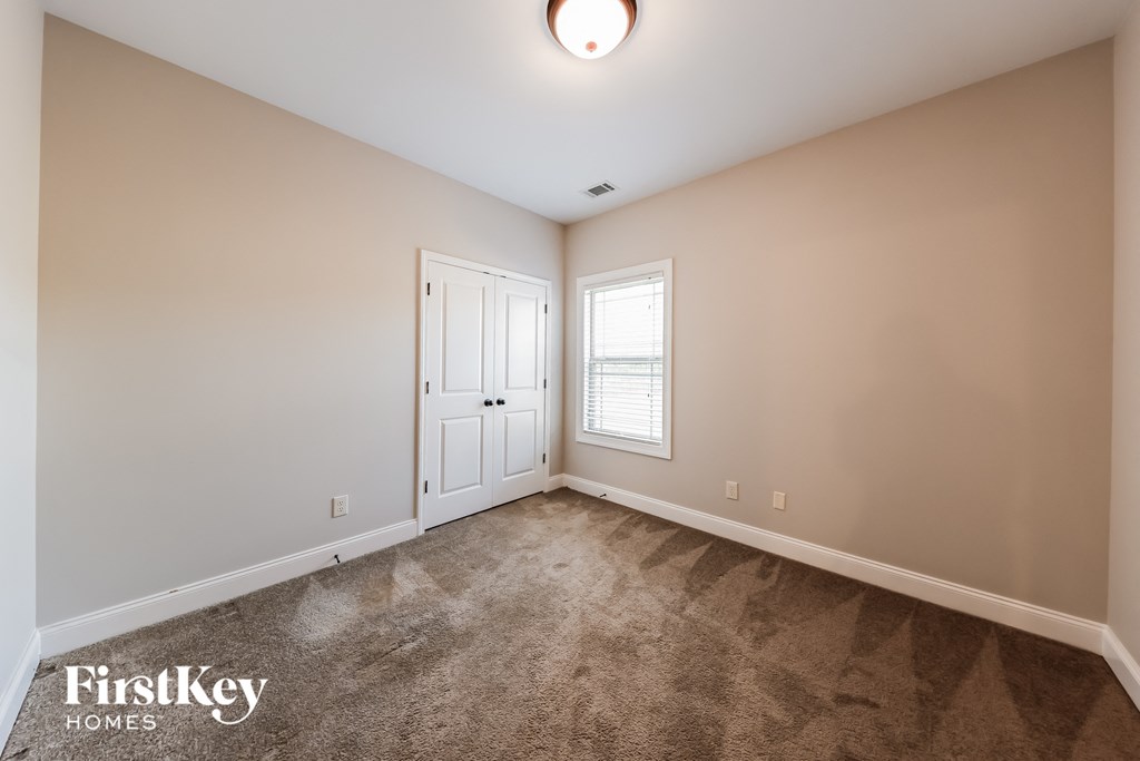 A room with a carpeted floor and a door leading to another room.