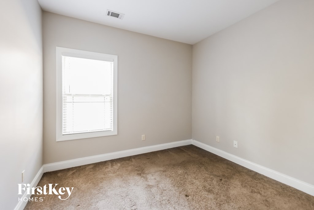 A room with a window and carpeted floor.