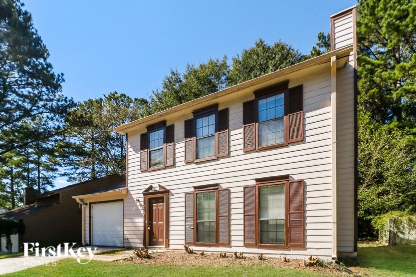 a white house with wooden shutters and a garage