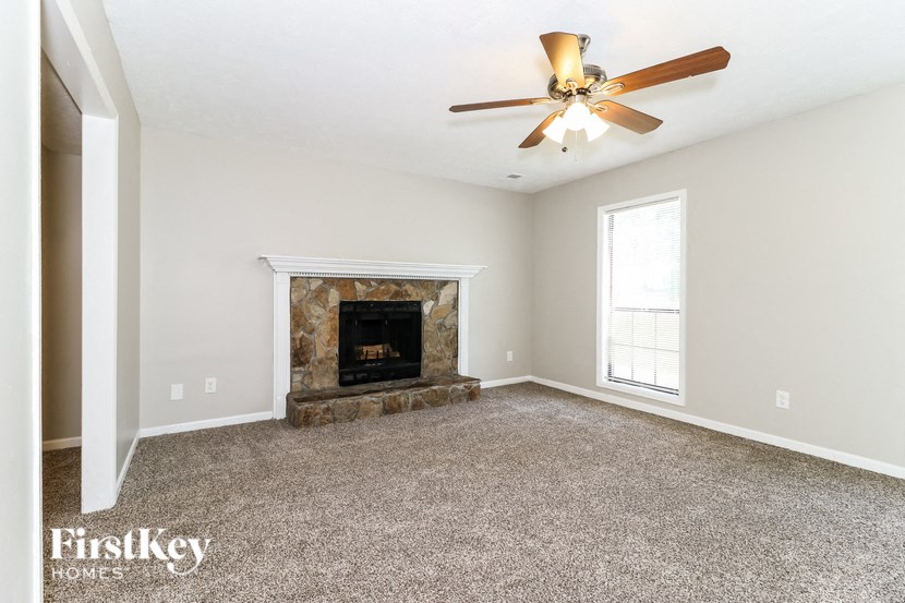 a living room with a fireplace and a ceiling fan