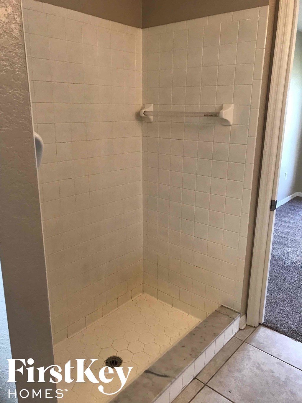 a small shower in a bathroom with a tiled floor