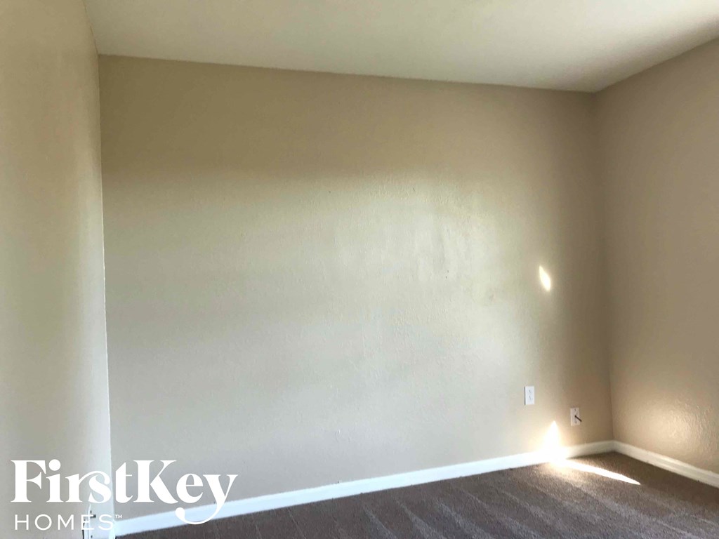 a blank wall in an empty room with a carpet