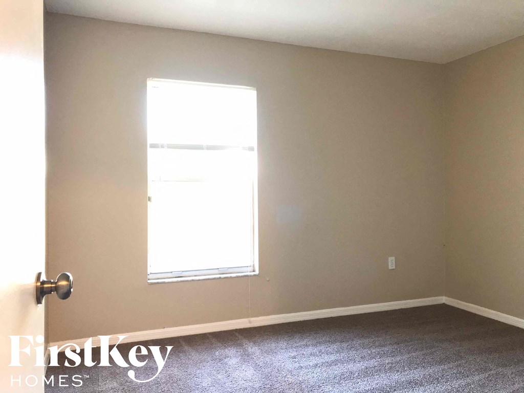 a room with a window and a carpeted floor