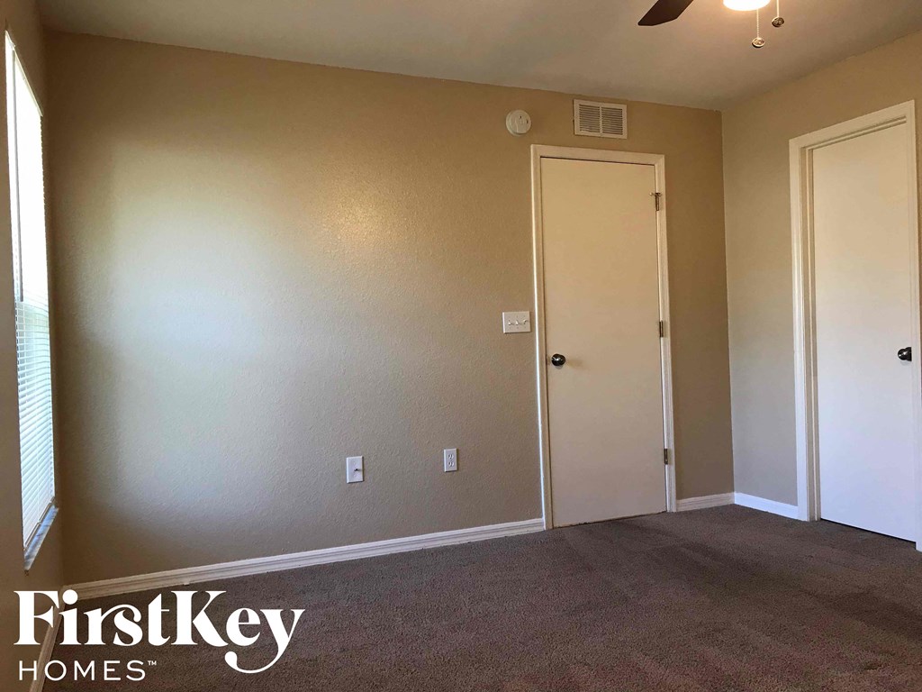 a room with a carpeted floor and a door to a closet