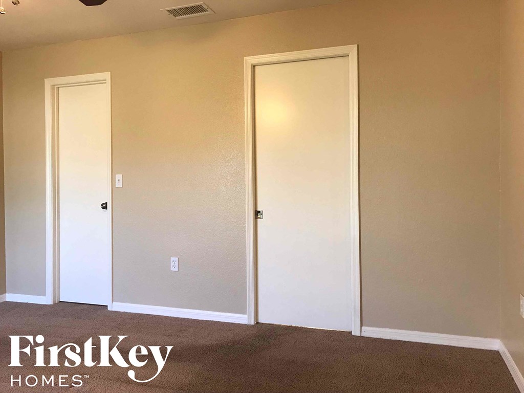 a room with white walls and two closet doors