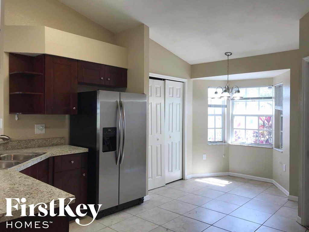 a kitchen with a stainless steel refrigerator and a window