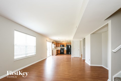 an empty living room with wood floors and a large window