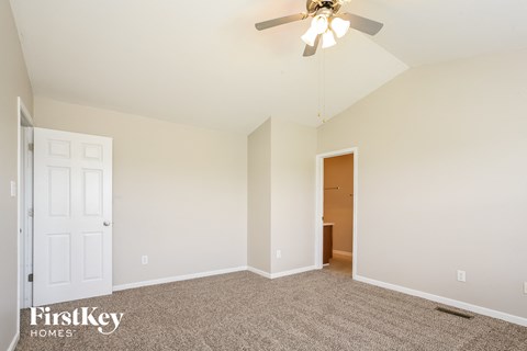 the living room of an empty home with a ceiling fan