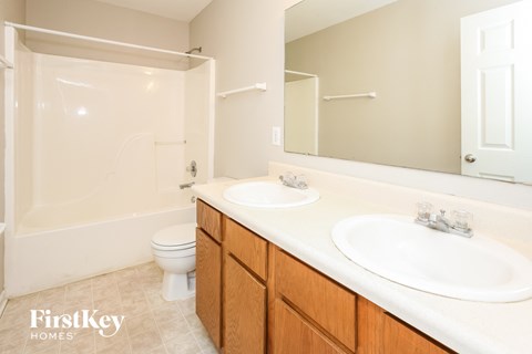 a bathroom with two sinks and a shower and a toilet