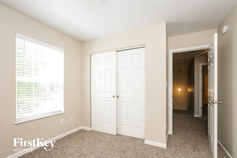a bedroom with two closets and a window and a door