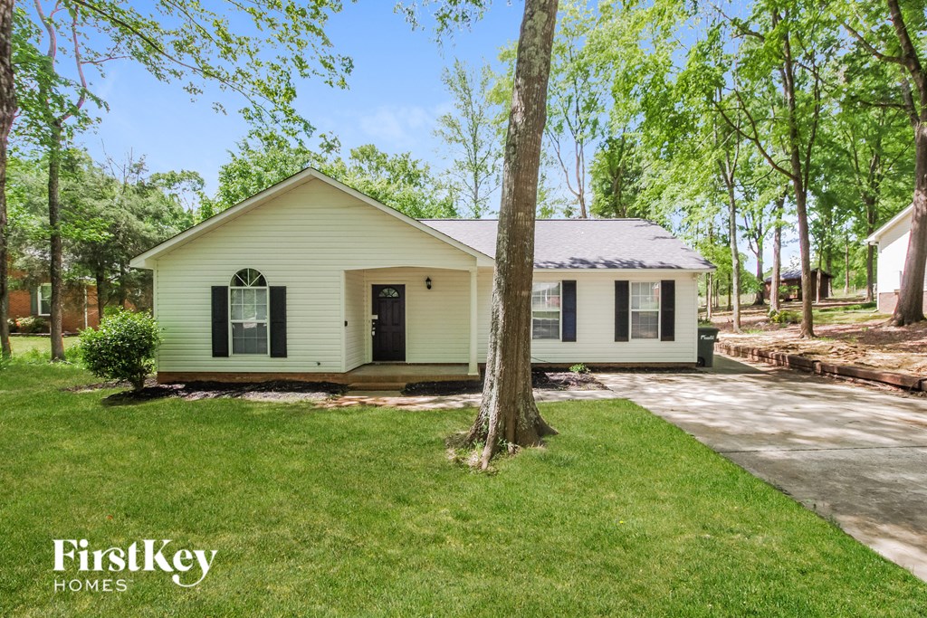 a small white house with a tree in front of it