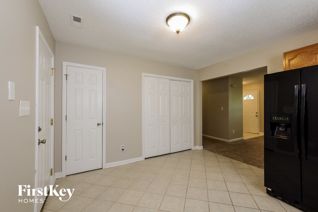 a dining room with two closets and a black refrigerator