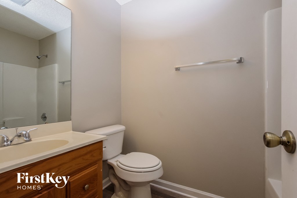 a bathroom with a toilet and a sink and a mirror