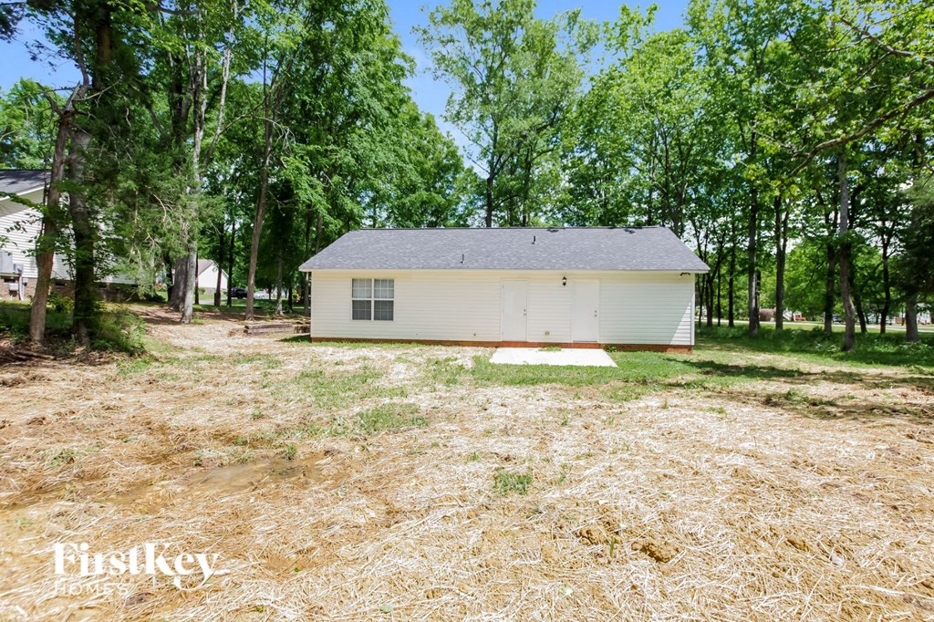 a small white house in a field with trees