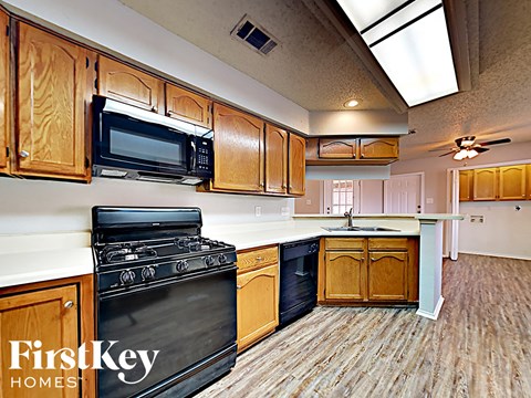A kitchen with wooden cabinets and a black stove top oven.