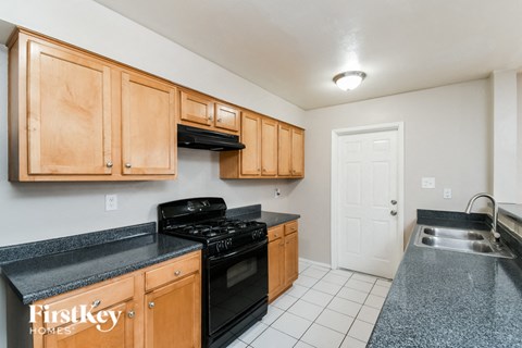 A kitchen with wooden cabinets and black appliances.