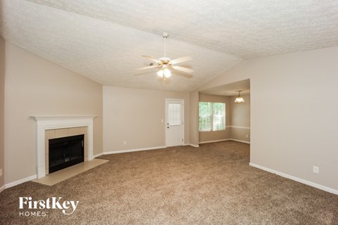 a living room with a fireplace and a ceiling fan