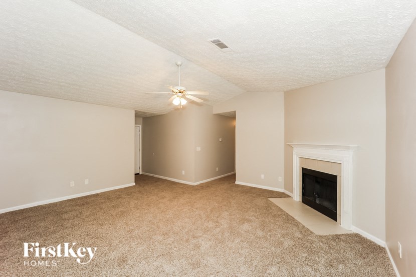 a living room with a fireplace and a ceiling fan