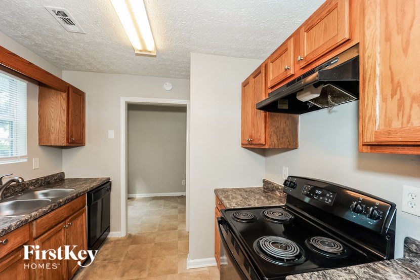 a kitchen with wood cabinets and a stove and a sink