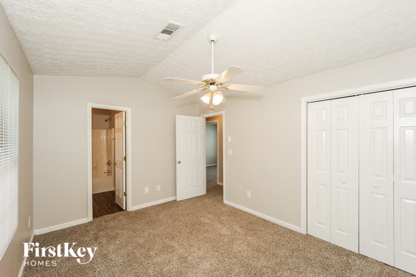 a bedroom with a ceiling fan and a closet