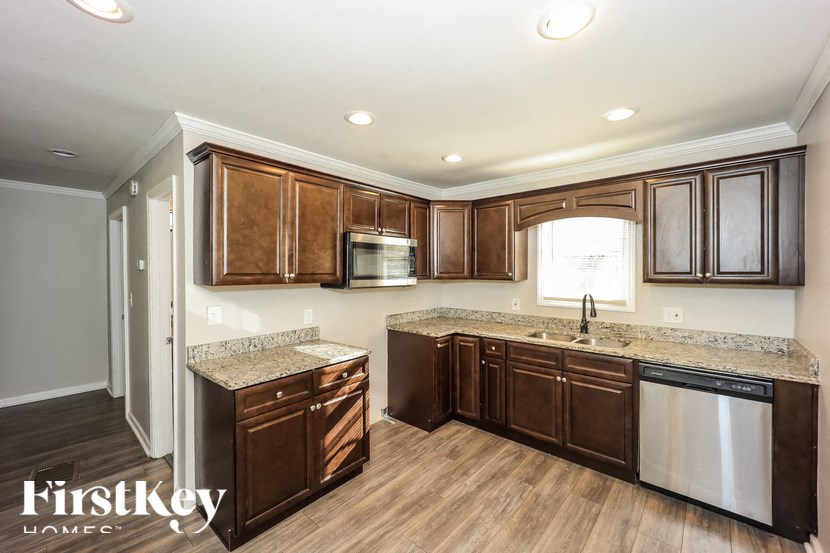 A kitchen with brown cabinets and a granite countertop.