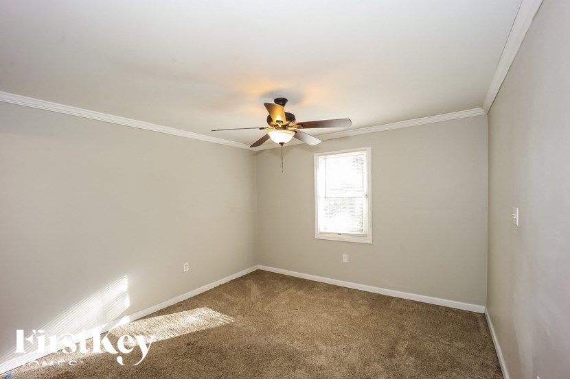 A room with a ceiling fan and a window.