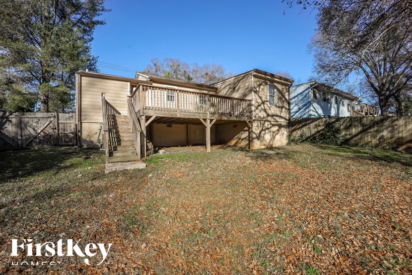 A house with a garage and a tree in front of it.