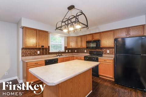 a kitchen with wooden cabinets and a white counter top