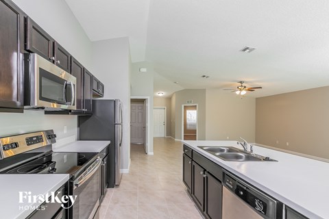 a kitchen with black appliances and white counter tops and a sink
