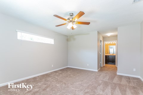 a living room with carpet and a ceiling fan
