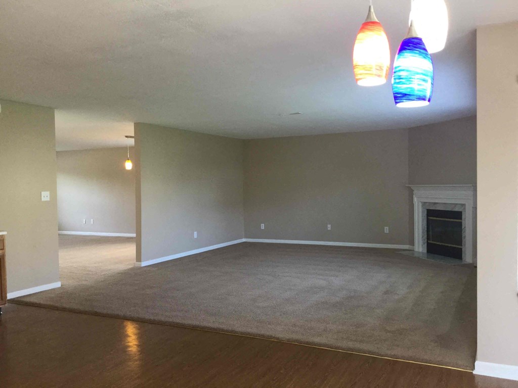 A living room with a fireplace and two hanging lights.